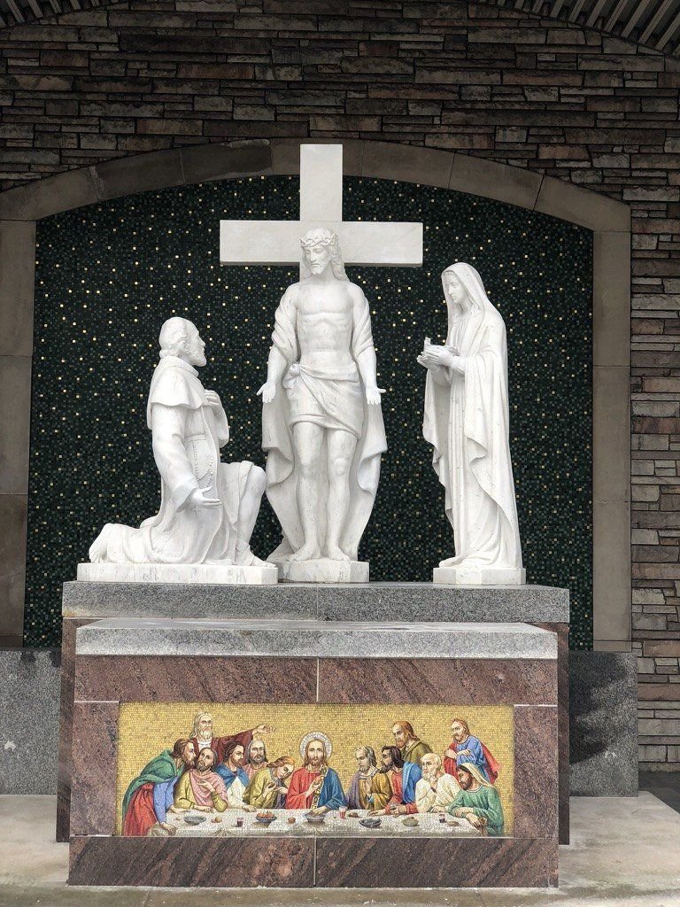 Restored exterior marble figure group above the decorated pedestal at St. Moses the Black.