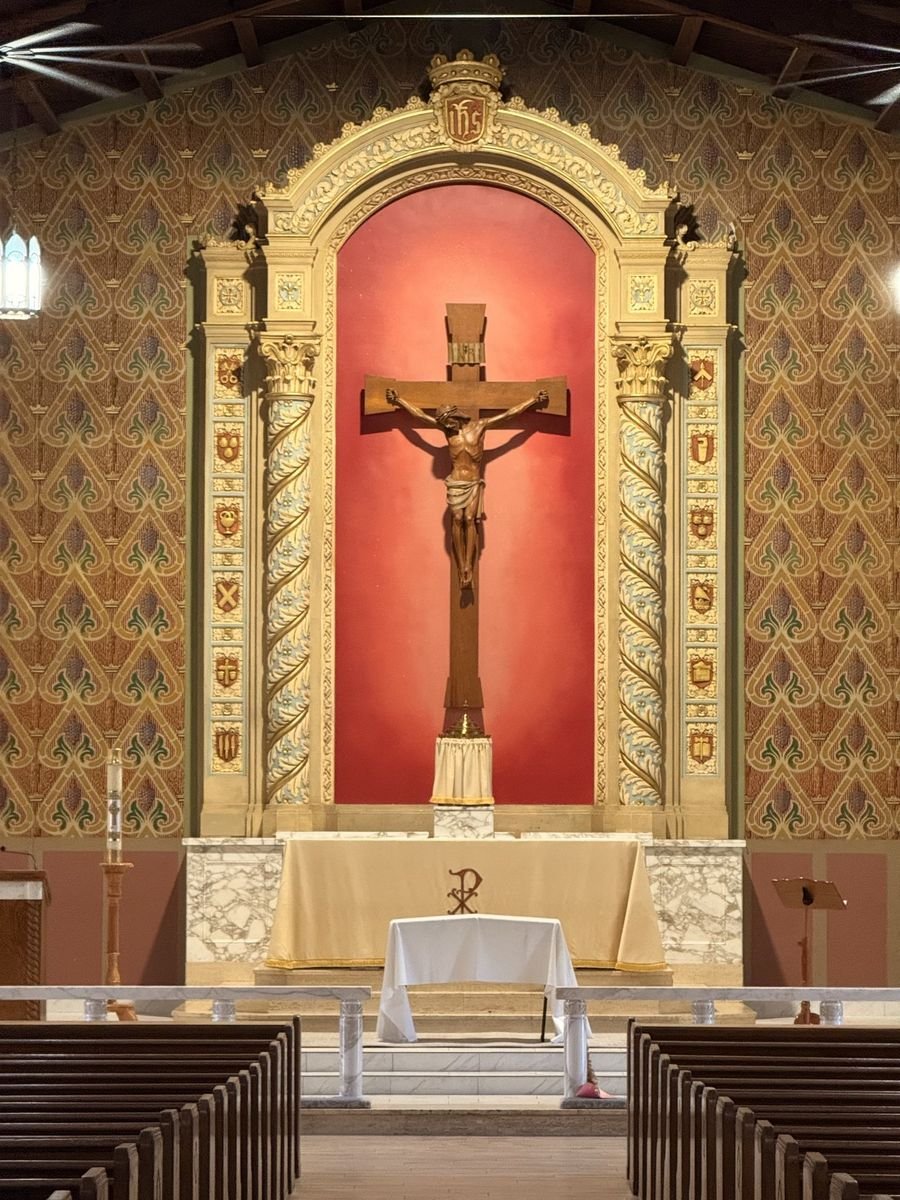 Restored reredos with a red crucifix niche viewed from the nave.