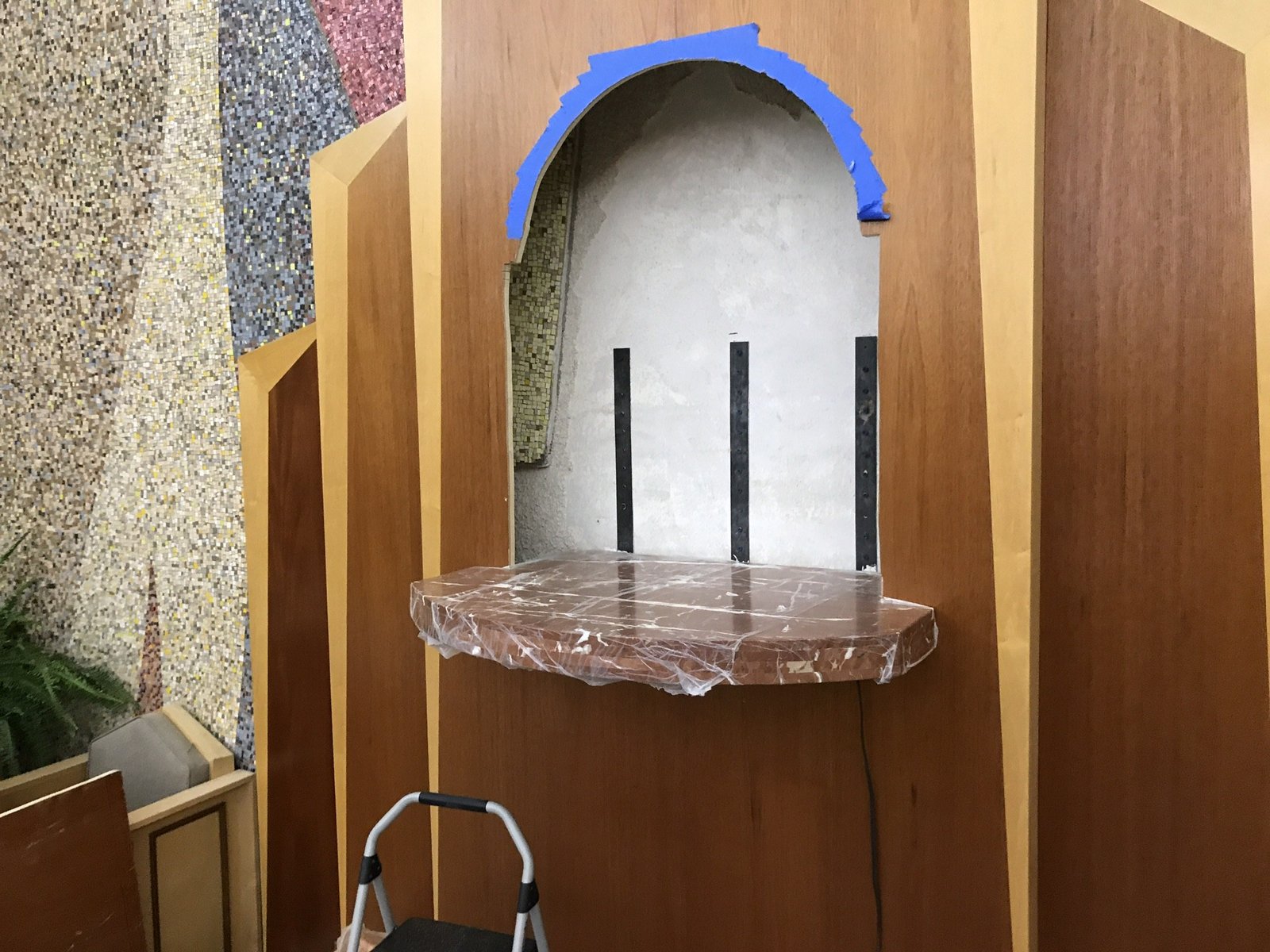 Marble tabernacle platform fitted into the wooden reredos beneath the niche opening.