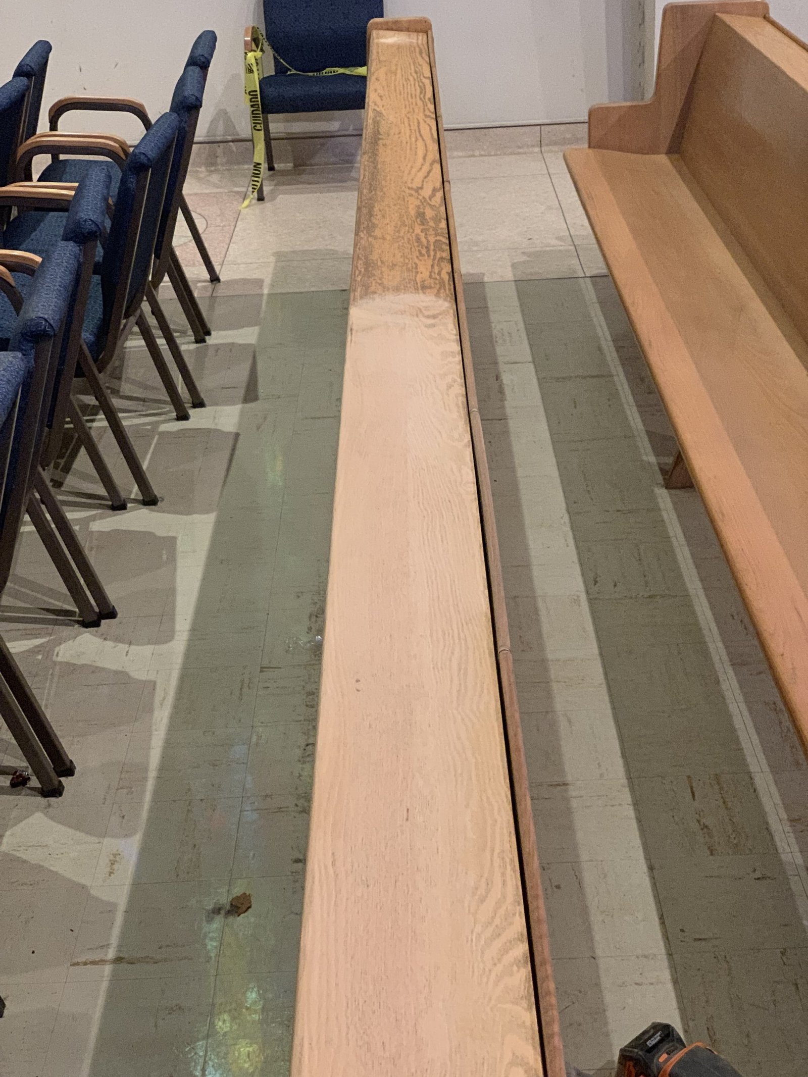 Light and dark sections along the top rail of a wooden pew