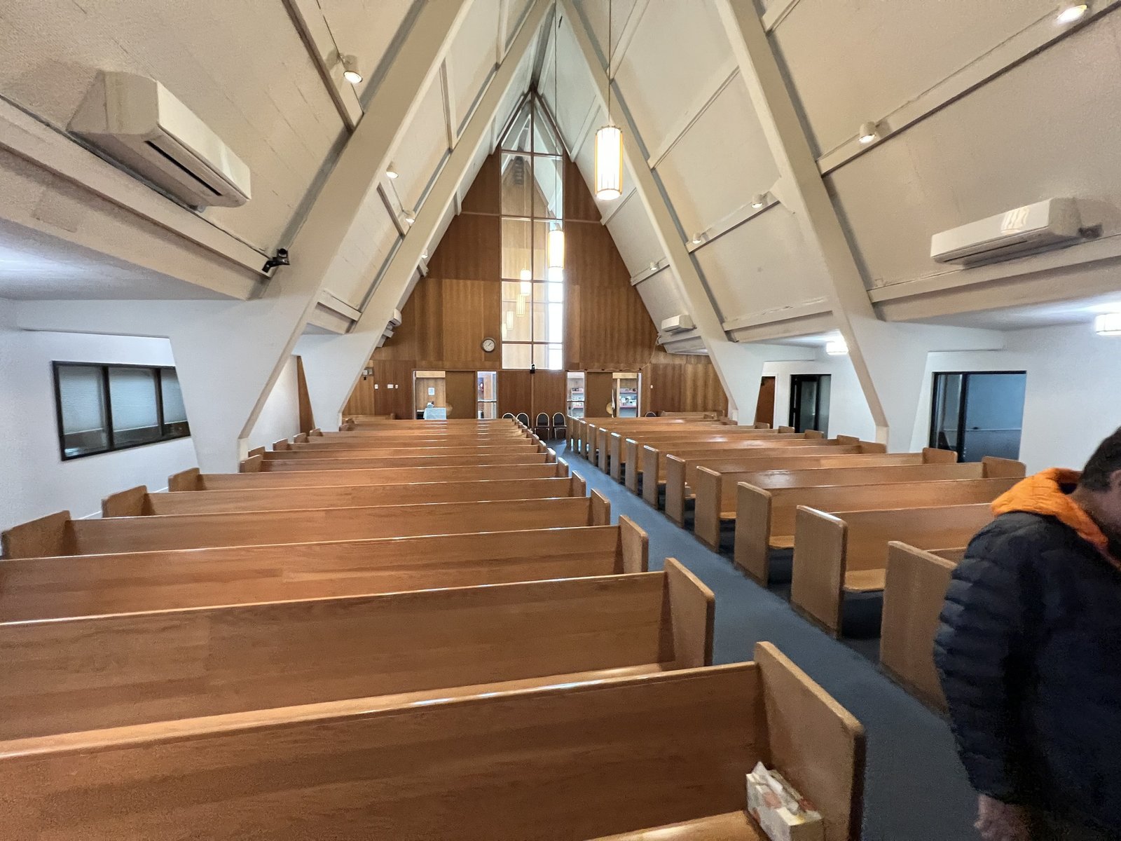 Rows of brown wooden pews looking toward the front of Covenant Reformed Church