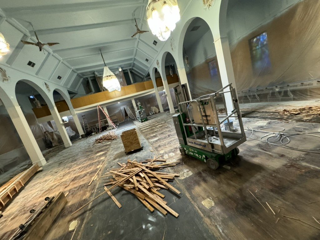 Cleared church interior with removed flooring and a lift.