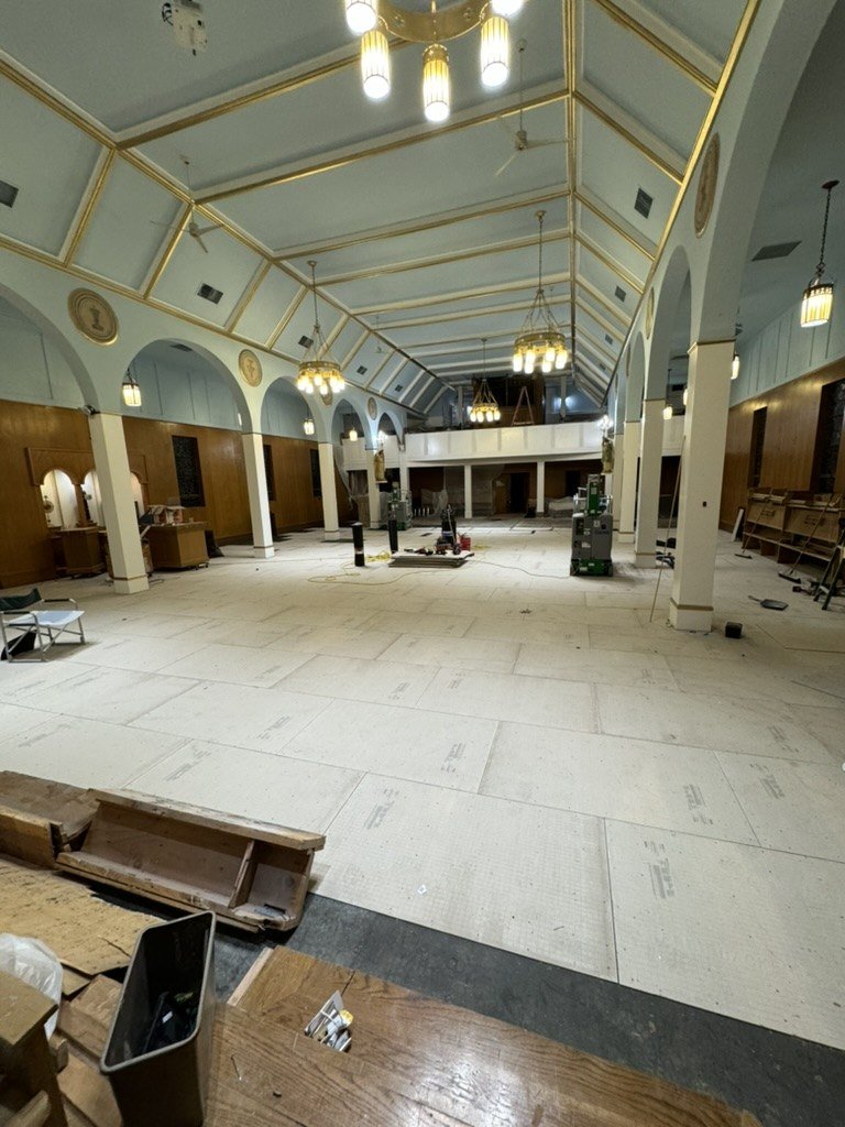 Church interior cleared of pews during repainting and floor work.