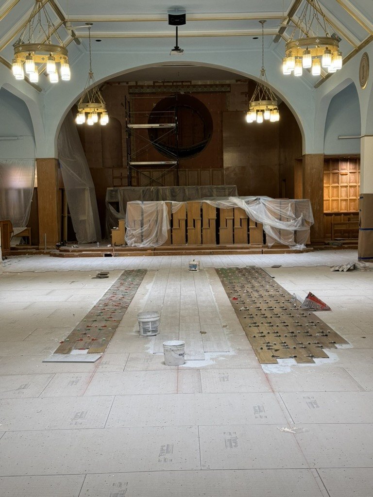 New floor work down the center aisle toward the protected altar.