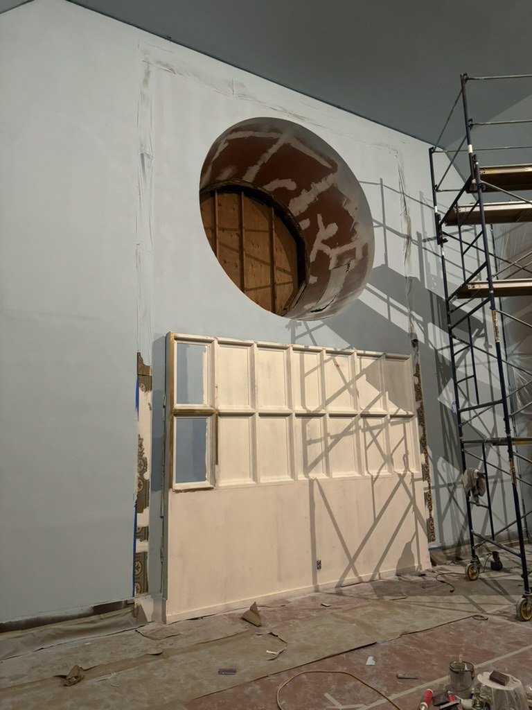Round window opening and framed sanctuary wall during remodeling.