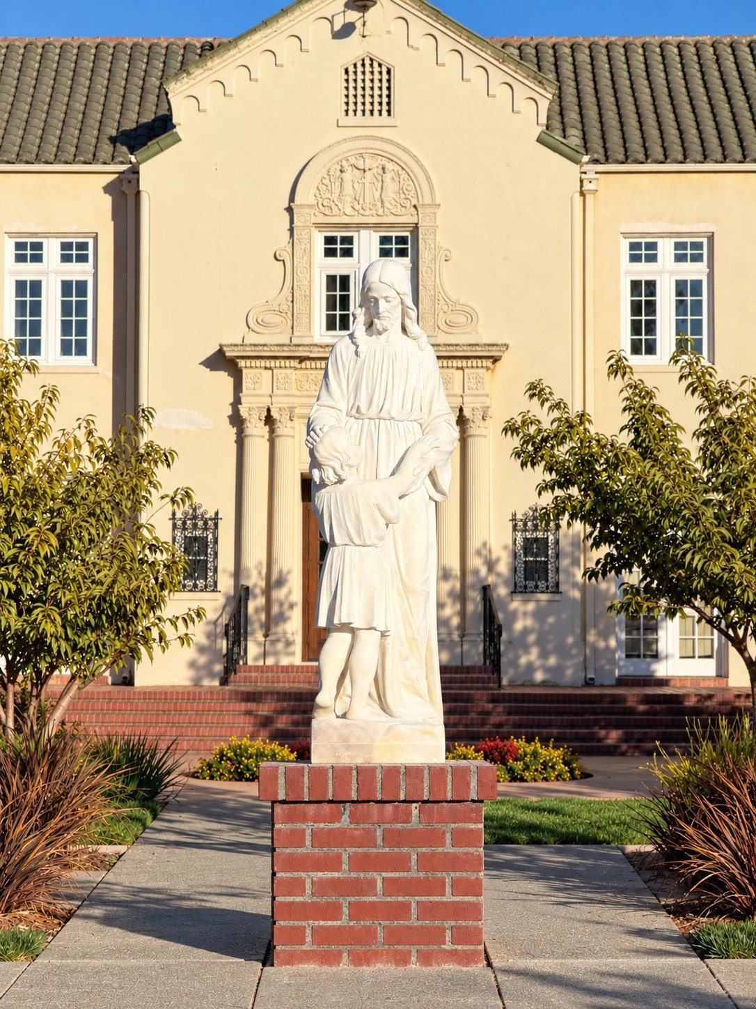 Standing figure and child on a brick pedestal outside Saint Vincent Church in San Rafael