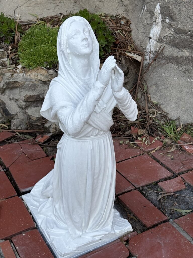 Restored kneeling marble figure with forearms and hands raised together.