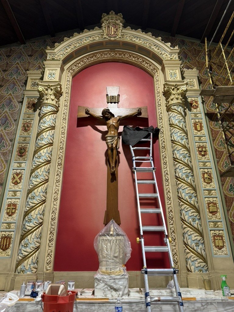 Ladder, scaffold and supplies in front of the crucifix and newly red niche.