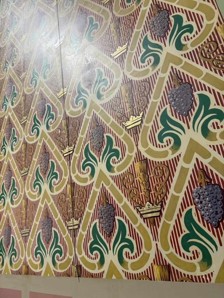 Repeating grape, leaf and grain pattern after restoration of the painted surface.