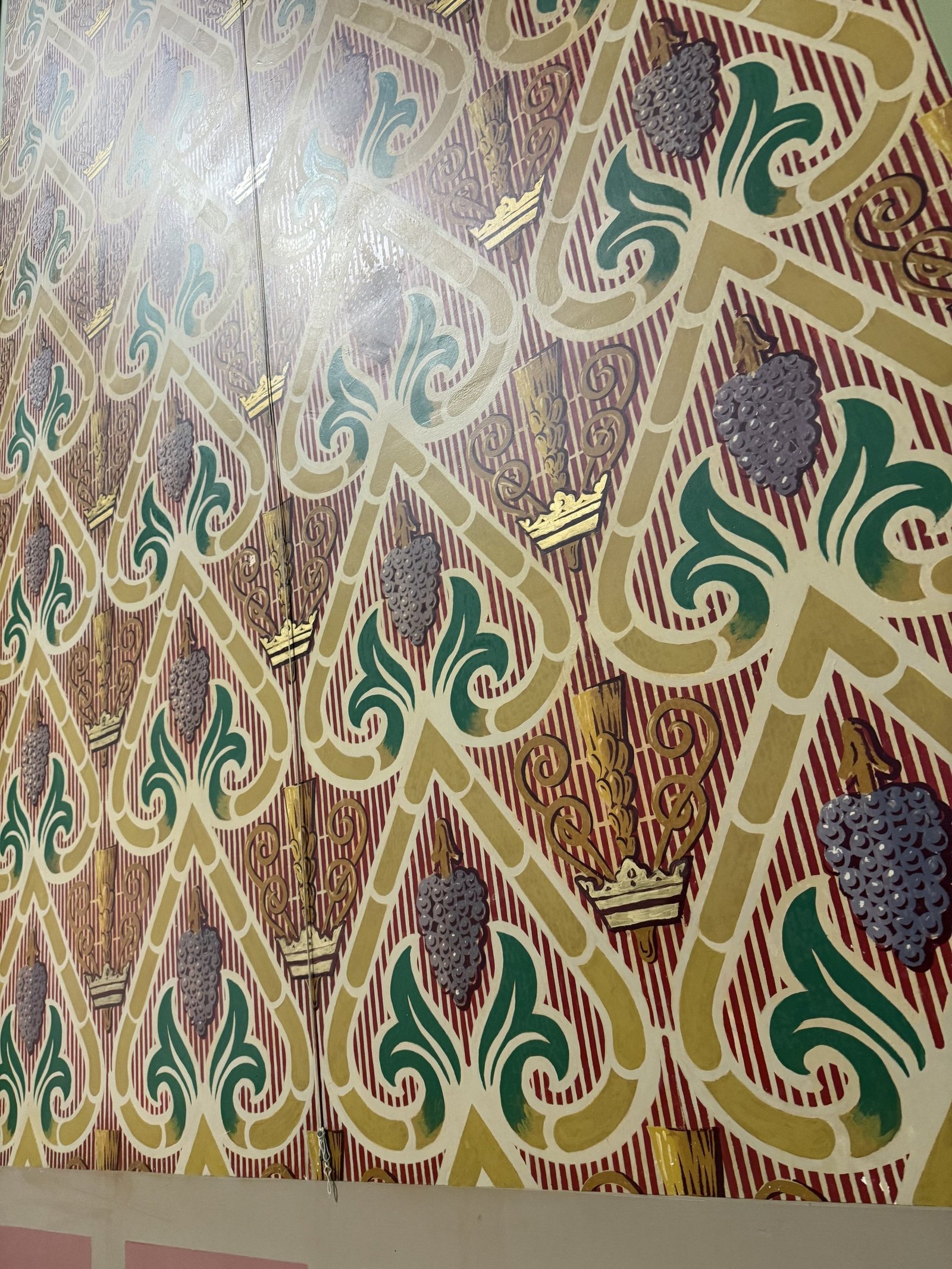 Repeating grape, leaf and grain pattern after restoration of the painted surface.