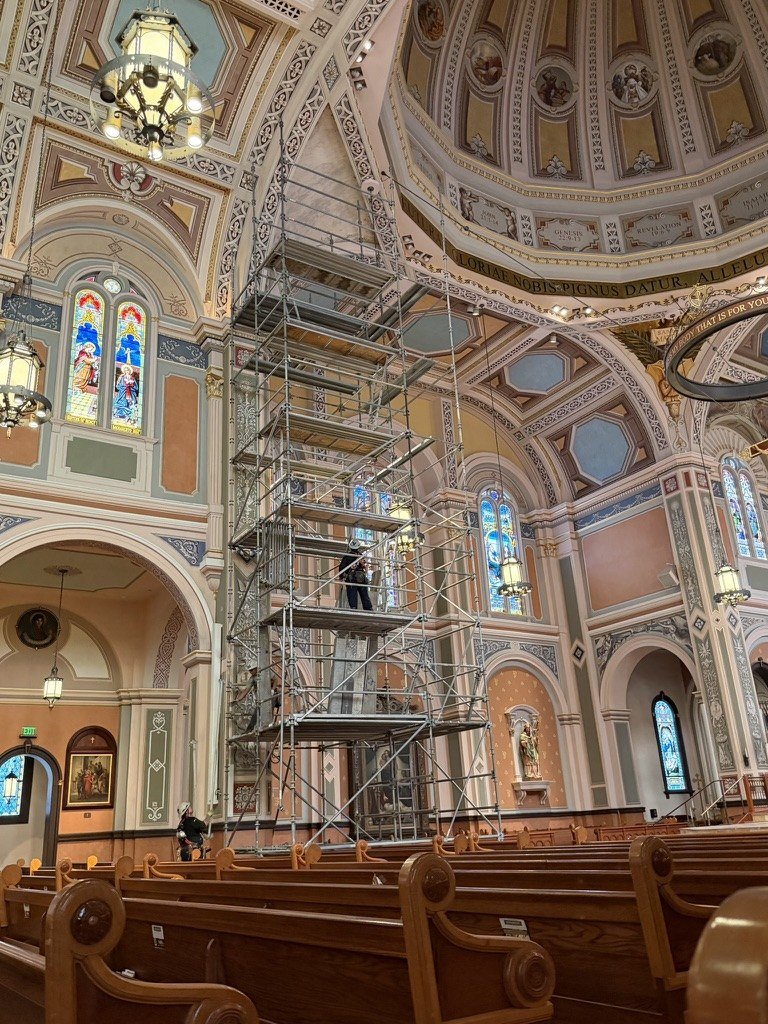 Scaffold tower rising from the pews to the cathedral ceiling.