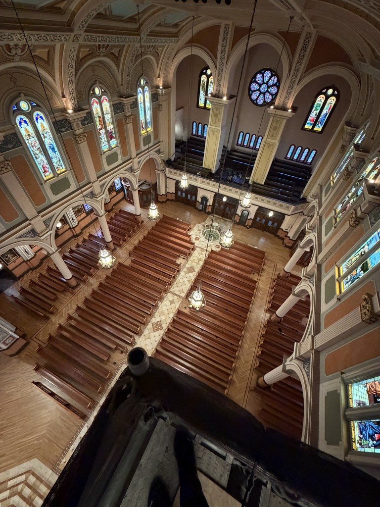 View down from a high scaffold platform over the pews and center aisle.