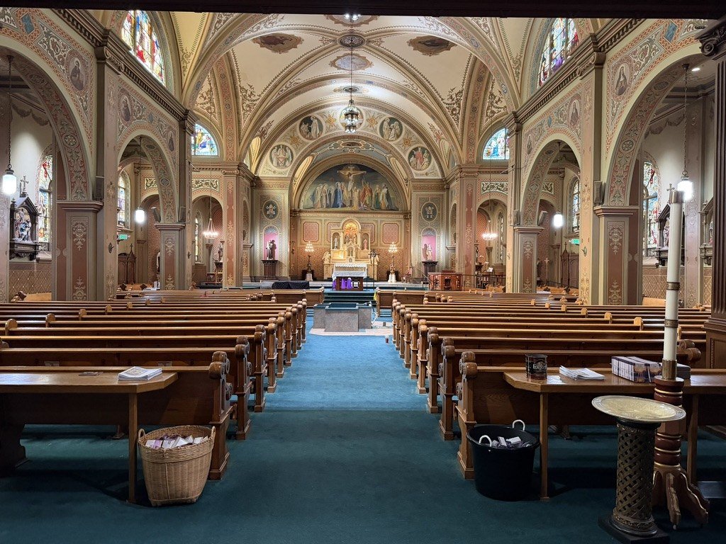 Church interior with a blue-green carpeted center aisle before the new flooring.