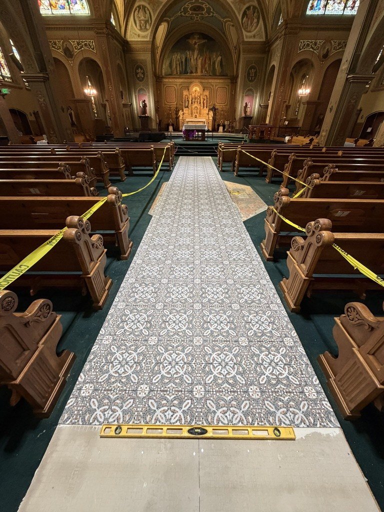 New patterned tile along the center aisle with a level and unfinished floor in the foreground.