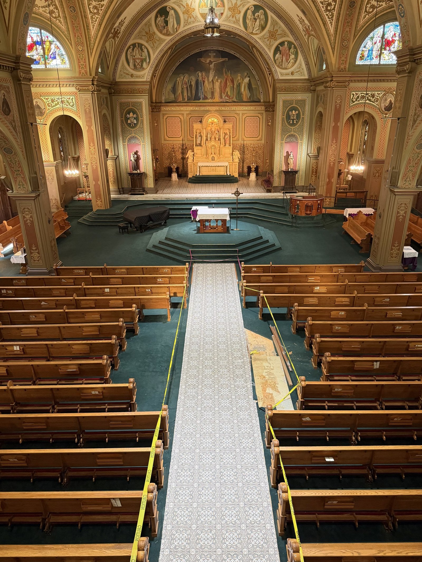 High view of the new patterned aisle floor with unfinished edges beside the pews.