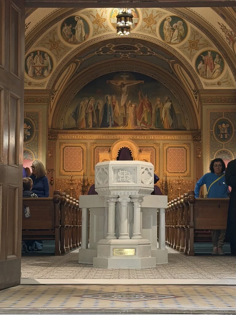 Restored historic font and new marble basin in the completed arrangement near the church doors.