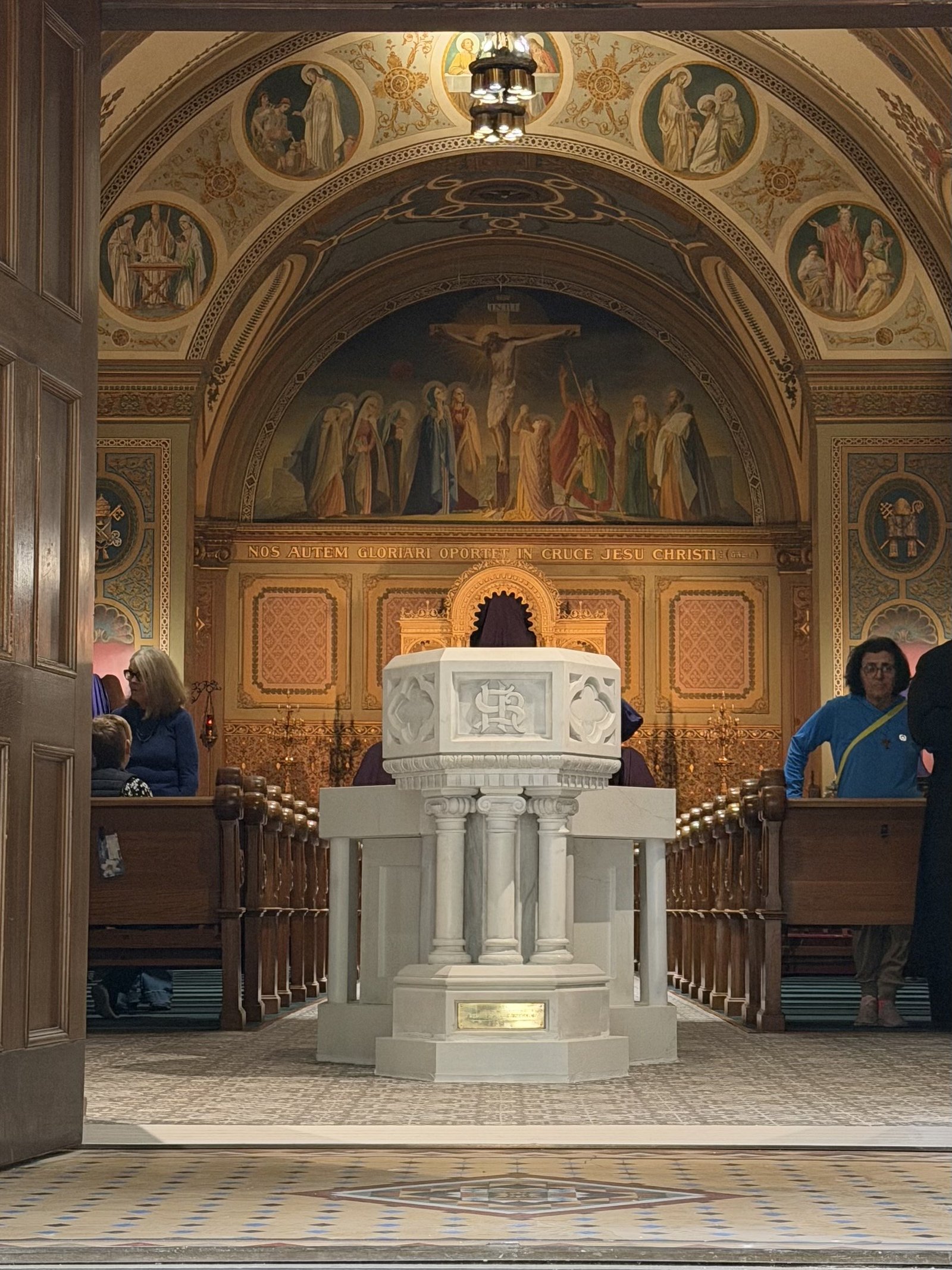 Restored historic font and new marble basin in the completed arrangement near the church doors.