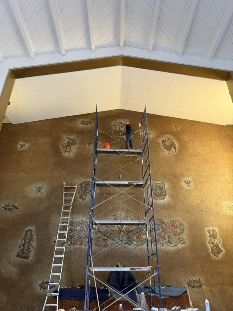 Worker on scaffolding high against the sanctuary mosaic wall.